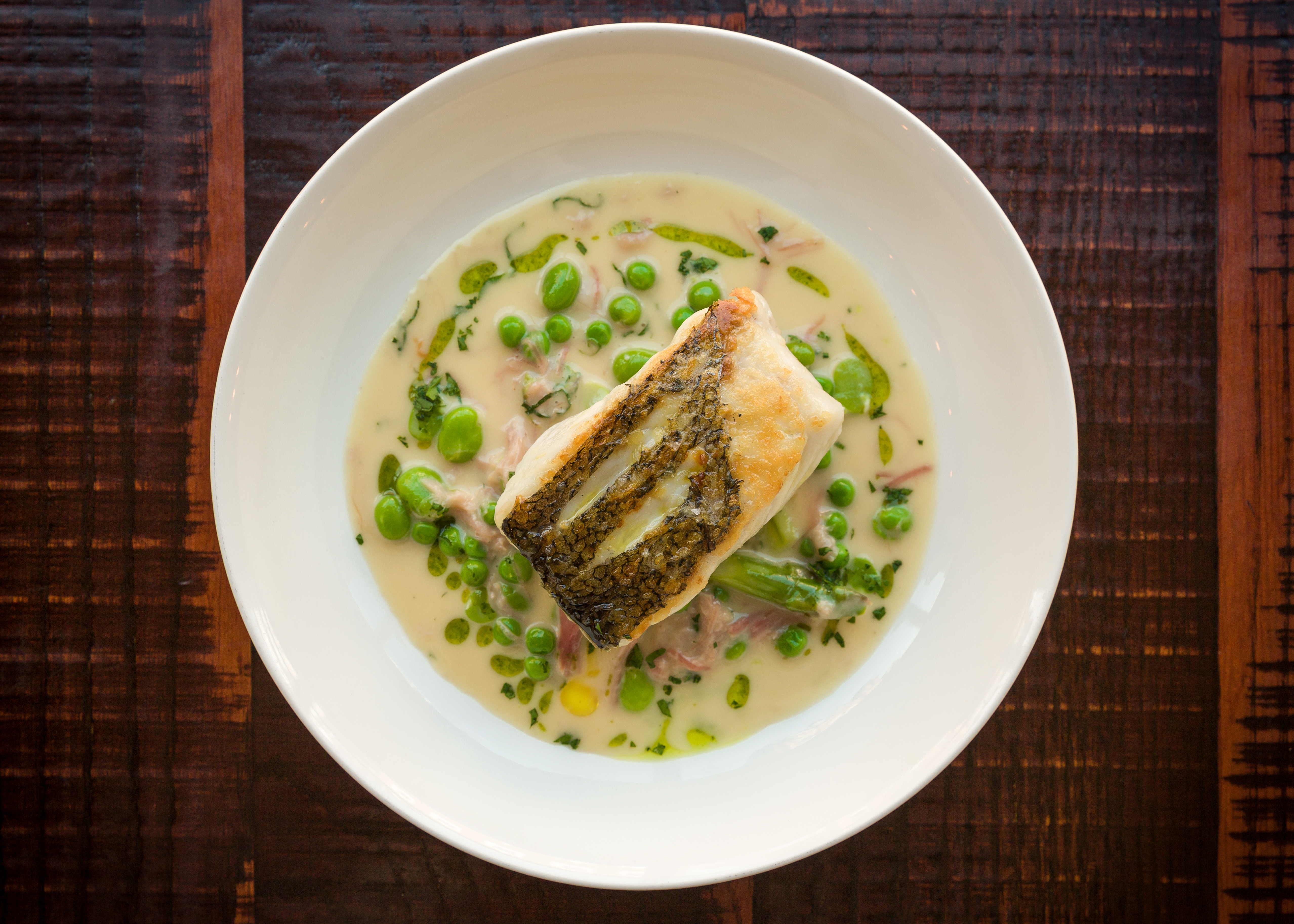 Fillet of hake with jamón, peas, broad beans and asparagus